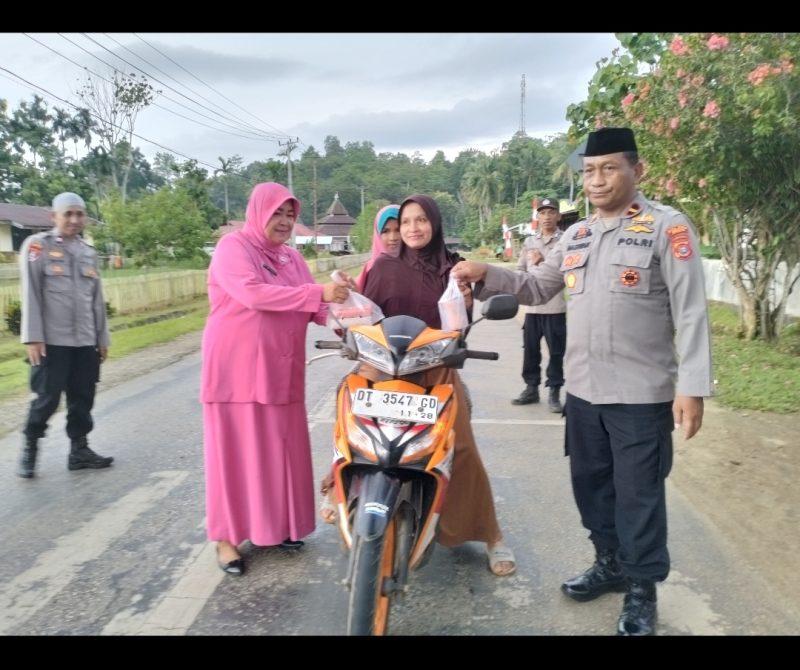 Kapolsek Lawa, IPDA Haswan bersama Ketua Bhayangkari Ranting Lawa, Ny Yanti Haswan saat bagi-bagi takjil di depan Mako Polsek Lawa, Senin (25/3). Foto: Dok